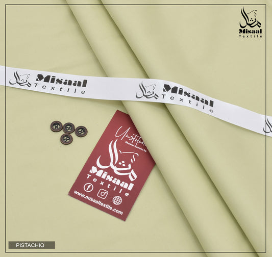Pistachio fabric with Misaal Textile branding, buttons, and a tag on a beige background.